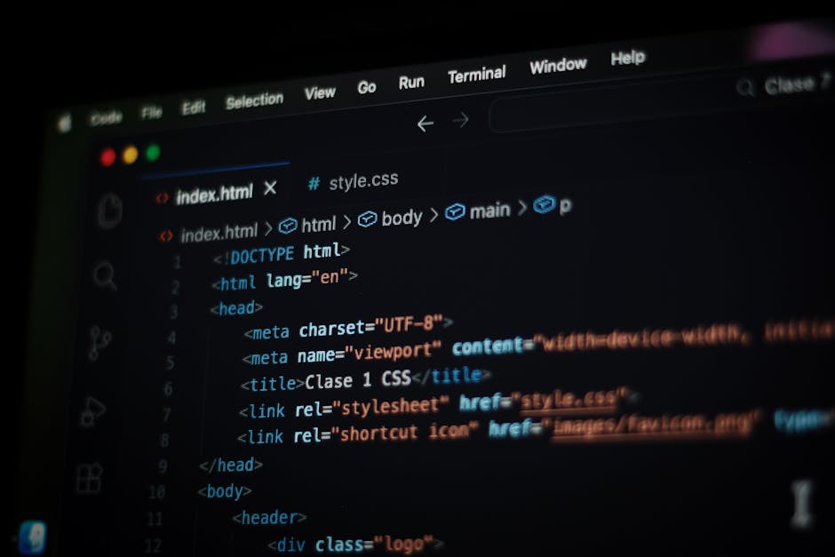 A close-up photograph of a computer screen displaying lines of code in various colors such as yellow, blue, red, and green, with a dark background. The code includes HTML elements, with tags like <h1>